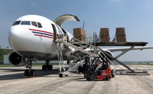 Cargo being loaded onto a Boeing 767 airplane utilizing a main deck loader